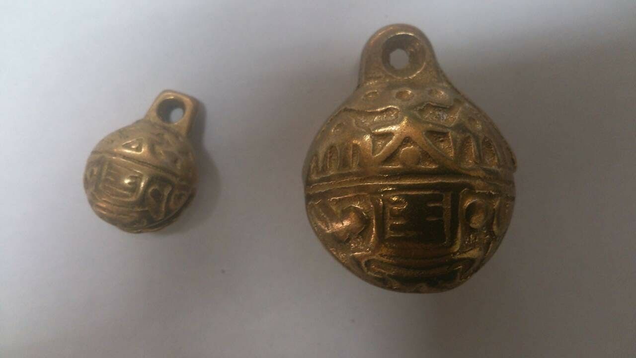 含鈴古銅色金屬鈴鐺，展示大小兩款圓形浮雕花紋鈴鐺，表面具有立體圖騰及頂部吊掛孔設計